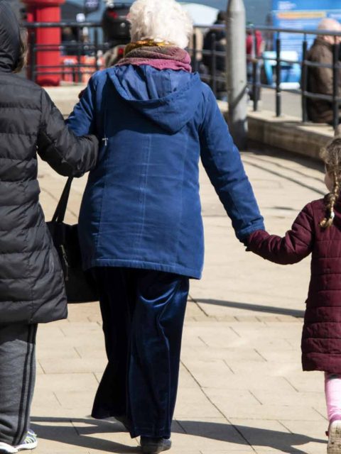 Three generations of people walking